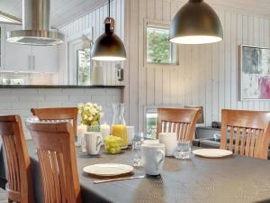 ein Esszimmer mit einem Tisch mit Stühlen und Lampen in der Unterkunft Holiday Home Ruzica - 3-9km from the sea by Interhome in Tagholm