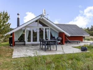 un padiglione con tavolo e sedie di fronte a una casa di Holiday Home Andriette - 4-5km from the sea by Interhome a Tagholm