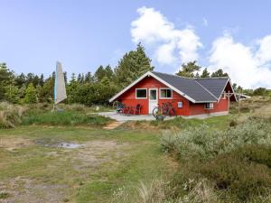 una casa rossa su una collina con un cortile di Holiday Home Andriette - 4-5km from the sea by Interhome a Tagholm