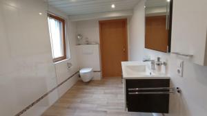 ein weißes Badezimmer mit Waschbecken und Toilette in der Unterkunft Ferienhaus Geller Radebeul Blick Friedensburg in Radebeul