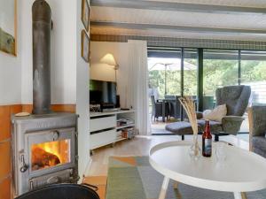 a living room with a wood stove and a table at Holiday Home Benedikta - 2-4km from the sea by Interhome in Vesterhede