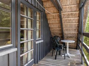a porch with two chairs and a table on it at Holiday Home Benedikta - 2-4km from the sea by Interhome in Vesterhede