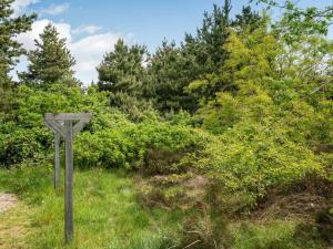 un panneau en bois dans l'herbe avec des arbres en arrière-plan dans l'établissement Holiday Home Livni - 3-8km from the sea by Interhome, à Tagholm