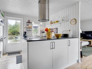 une cuisine avec des armoires blanches et un comptoir dans l'établissement Holiday Home Fredrikka - 3-9km from the sea by Interhome, à Tagholm