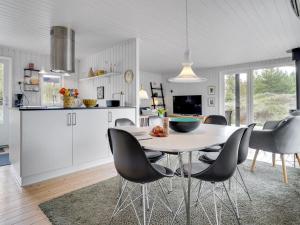 une cuisine et une salle à manger avec une table et des chaises dans l'établissement Holiday Home Fredrikka - 3-9km from the sea by Interhome, à Tagholm
