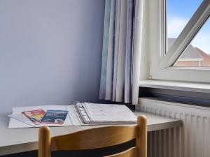 a desk with a book and a window at Apartment Aldora - 2-3km from the sea by Interhome in Sønderby