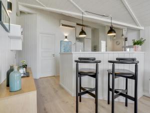 a kitchen with two bar stools and a counter at Holiday Home Freek - 400m from the sea by Interhome in Lakolk +35 photos