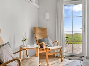 ein Wohnzimmer mit einem Stuhl und einem Tisch in der Unterkunft Holiday Home Henrietta - 3-5km from the sea by Interhome in Kongsmark