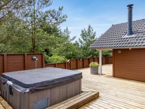 a backyard with a hot tub on a wooden deck at Holiday Home Svenny - 800m from the sea by Interhome in Lakolk +27 photos