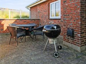a bbq grill sitting next to a brick wall at Holiday Home Hendrine - 500m from the sea by Interhome in Lakolk