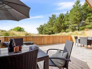 a patio with a table and chairs and an umbrella at Holiday Home Alessia - 2km from the sea by Interhome in Lakolk