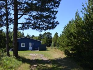 a blue house in the middle of a yard at Holiday Home Redward - 1km from the sea by Interhome in Mølby