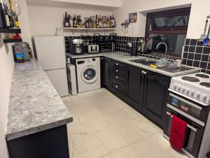 Il comprend une cuisine équipée d'un lave-linge, d'un évier et d'un lave-vaisselle. dans l'établissement Central Cornwall Stay, à Redruth