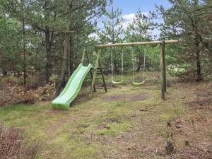 ein Spielplatz mit einer grünen Rutsche im Wald in der Unterkunft Holiday Home Volmar - 3-5km from the sea by Interhome in Kongsmark + 21 Fotos