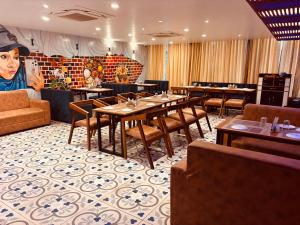 a restaurant with tables and chairs and a couch at Hotel Chariot Inn in Deoghar