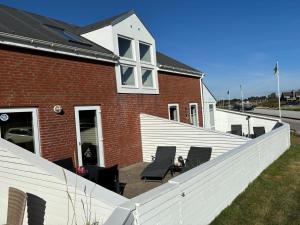 a brick house with a white fence in front of it at Apartment Bosse - 2-3km from the sea by Interhome in Sønderby