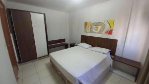 a small bedroom with a white bed and a mirror at Boulevard Park in Caldas Novas +12 photos