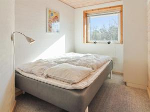 a bed in a room with a window at Holiday Home Brigida - 500m from the sea by Interhome in Lakolk