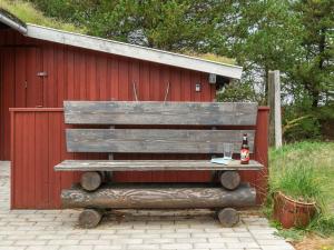 a wooden bench sitting next to a red building at Holiday Home Nandolf - 3-5km from the sea by Interhome in Bolilmark