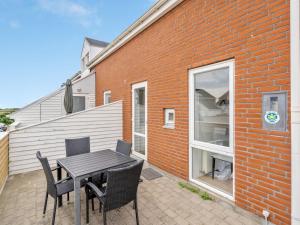 a patio with a table and chairs next to a brick building at Apartment Anke - 500m from the sea by Interhome in Sønderby