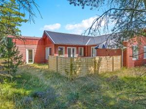 une maison rouge avec une clôture devant dans l'établissement Holiday Home Dorreth - 800m from the sea by Interhome, à Mølby