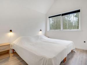 a white bedroom with a bed and a window at Holiday Home Lima - 3-5km from the sea by Interhome in Kongsmark