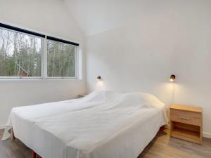 a white bedroom with a bed and a window at Holiday Home Lima - 3-5km from the sea by Interhome in Kongsmark