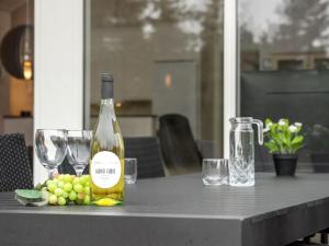 a bottle of wine sitting on a table with wine glasses at Holiday Home Lima - 3-5km from the sea by Interhome in Kongsmark