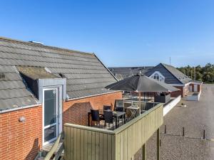 Una terraza al aire libre con sombrilla, mesas y sillas. en Apartment Reimund - 2-3km from the sea by Interhome, en Sønderby