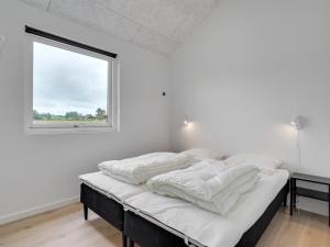 una camera da letto con un letto con lenzuola bianche e una finestra di Holiday Home Fridel - 4km from the sea by Interhome a Tagholm