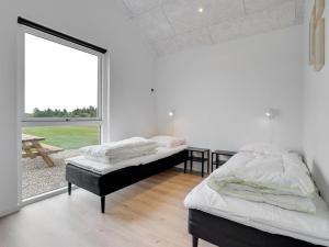 due letti in una stanza con una grande finestra di Holiday Home Fridel - 4km from the sea by Interhome a Tagholm