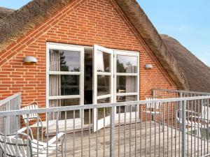 a brick house with two chairs and a balcony at Holiday Home Henrike - 3-3km from the sea by Interhome in Toftum +16 photos