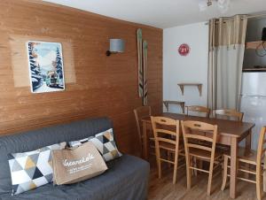 a living room with a couch and a table and chairs at ASTERS -A05- Studio lumineux 4-6 pers in Chamrousse