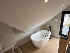 a white bath tub sitting in a room at Fire Station View-Central-2 king beds-Brand new interior in Topsham