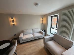 a living room with two couches and a table at Fire Station View-Central-2 king beds-Brand new interior in Topsham