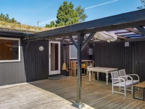 eine Terrasse mit einem Holzdeck mit Tisch und Stühlen in der Unterkunft Holiday Home Elin - 3km from the sea by Interhome in Bolilmark