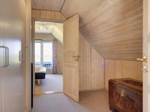an attic room with a door leading to a bedroom at Holiday Home Helfrida - 350m from the sea by Interhome in Lakolk