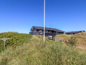 a house on top of a hill with a pole at Holiday Home Alim - 300m from the sea by Interhome in Lakolk +20 photos
