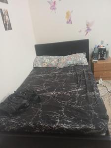 a bed with a black comforter on top of it at Holiday villa al dhafra region ghayathhi in Abu Dhabi