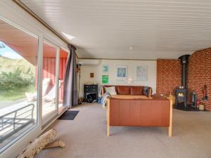 Una sala de estar con un sofá y una ventana. en Holiday Home Borjana - 800m from the sea by Interhome, en Oksbøl
