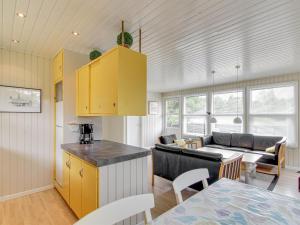 eine Küche und ein Wohnzimmer mit gelben Schränken in der Unterkunft Holiday Home Nanouk - 500m from the sea by Interhome in Vejers Strand