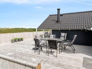 a patio with a table and chairs on a deck at Holiday Home Betti - 200m from the sea by Interhome in Lakolk