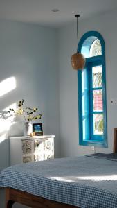 a bedroom with a blue window and a dresser at MayHome Binh Dinh in An Hòa