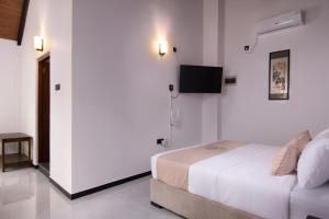 a bedroom with a bed and a flat screen tv at Mr & Mrs K's Villa- Kandy in Kandy