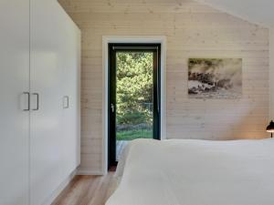 a bedroom with a white bed and a window at Holiday Home Tea - 2-7km from the sea by Interhome in Bolilmark