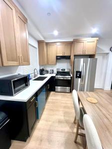a kitchen with wooden cabinets and a table with a microwave at Culver Hideaway Private Room with Share Living Space C1 in Los Angeles