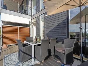 a patio with a table and chairs and an umbrella at Apartment Theis - 100m from the sea by Interhome in Havneby