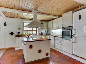 a kitchen with white cabinets and a white refrigerator at Holiday Home Iiro - 2-5km from the sea by Interhome in Rømø Kirkeby