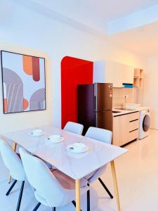 a kitchen with a white table and chairs and a refrigerator at Majestic Residence Klcc in Kuala Lumpur