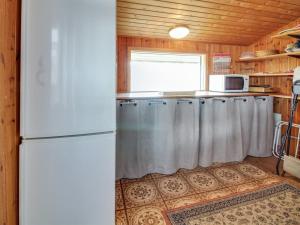 a kitchen with a white refrigerator and a window at Holiday Home Dalia - 200m from the sea by Interhome in Vejers Strand